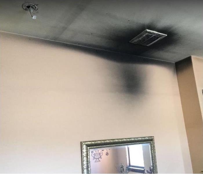 smoke and soot around air vent in ceiling; smoke and soot on wall and ceiling