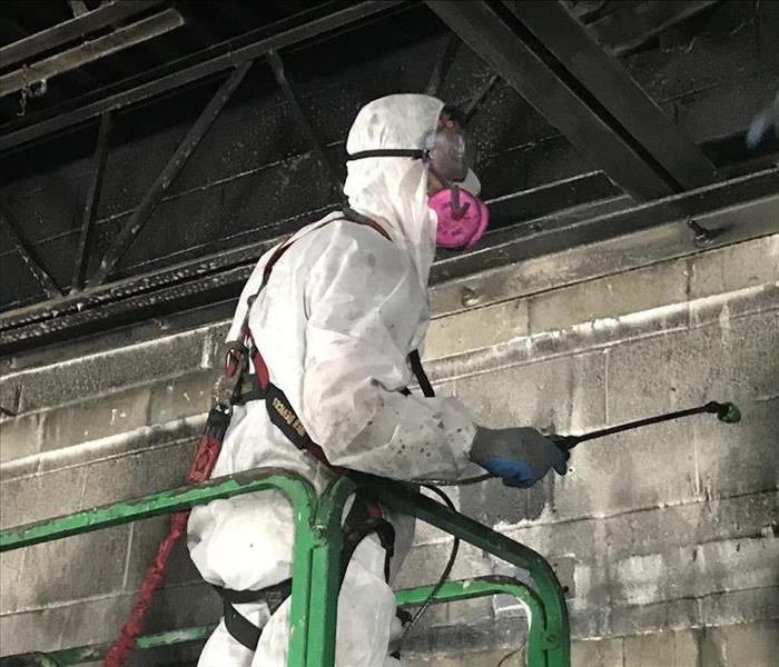manlift cleaning soot from warehouse