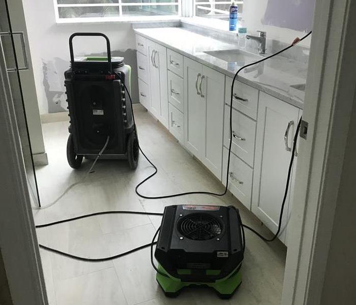 A bathroom with SERVPRO equipment on the floor. 